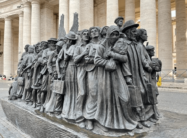 Standbeeld Angels Unawares op St. Pietersplein te Rome weerspiegelt het lot van migranten door de geschiedenis heen samengepropt op een boot met de heilige familie. Middenin die massa mensen zie je de vleugels van een engel boven de hoofden uitsteken.
Het beeld dankt zijn naam aan de uitspraak ‘En vergeet de gastvrijheid niet; door haar hebben sommigen zonder het te weten engelen onthaald’ (Brief aan de Hebreeën, vers 13:2).
Op zondag 29 september 2019 onthulde de paus het nieuwe standbeeld op het Sint Pietersplein: Angels Unawares. Het beeld is gemaakt door de Canadese kunstenaar Timothy Schmalz.
Foto: Gemma van der Linde